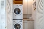 Laundry room with front-loading stacked washer/dryer.